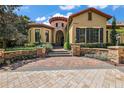 Stunning exterior view of home with turret feature and brick paver driveway and stone wall at 32543 Hawks Lake Ln, Sorrento, FL 32776