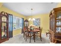 Formal dining room with chandelier, traditional furnishings, and natural light from a window at 3441 Landing Vw, Tavares, FL 32778