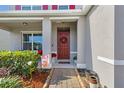 Inviting covered front porch and entry with beautiful landscaping and a wreath on the door at 3441 Landing Vw, Tavares, FL 32778