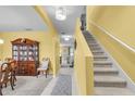 Bright hallway featuring tile flooring, a staircase and traditional furnishings at 3441 Landing Vw, Tavares, FL 32778