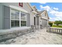 Close-up of the home's facade, featuring a stone planter and hardscape and gray shutters at 3537 Cluster Ct, The Villages, FL 32163