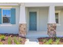 Close-up of a stylish front door with stone pillar accents and well-maintained landscaping at 5036 Blanket Flower St, Apopka, FL 32712