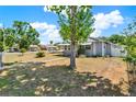 A wide view of the charming home surrounded by a neatly maintained lawn and some mature trees at 506 Richard St, Leesburg, FL 34748