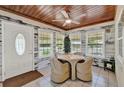 Cozy sun room features wood ceiling, tiled floors, a ceiling fan, and great natural light at 506 Richard St, Leesburg, FL 34748