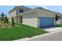 Beige home with a blue two-car garage, and an ample lawn and landscaped area at 5105 Blanket Flower St, Apopka, FL 32712
