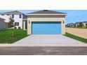 Exterior of home featuring a two-car garage and large concrete driveway at 5125 Waypointe Blvd, Apopka, FL 32712