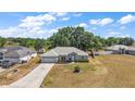 Angle aerial view of a single-story home with a manicured lawn, two car garage, and mature landscaping at 529 Ed Douglas Rd, Groveland, FL 34736
