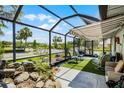 Relaxing screened lanai with comfortable seating and a view of the lush landscaping at 5500 Laver St, Leesburg, FL 34748