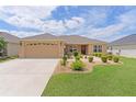 Attractive single-Gathering home with a well-maintained lawn, complemented by a convenient two-car garage at 5596 Cedar Waxwing Dr, The Villages, FL 32163