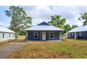 Charming blue home with a metal roof and a well-maintained front yard at 646 Nw 9Th Ave, Webster, FL 33597