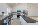 Modern kitchen with white cabinetry, stainless steel appliances, and a large island at 646 Nw 9Th Ave, Webster, FL 33597