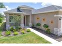 Charming home exterior with a well-manicured lawn, stone accents, and decorative floral accents at 8664 Bridgeport Bay Cir, Mount Dora, FL 32757