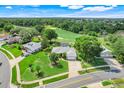 Aerial view of single-Gathering home near a golf course with green landscaping and mature trees at 8709 Augusta Ct, Clermont, FL 34711