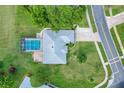 Aerial view of a single Gathering home with a screened-in pool, driveway, and lush landscaping at 8709 Augusta Ct, Clermont, FL 34711