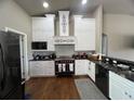 Charming kitchen featuring custom white cabinetry, modern appliances, and elegant black countertops at 9010 Laurel Ridge Dr, Mount Dora, FL 32757