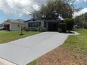 Charming single-story home with landscaped front yard and long concrete driveway at 941 Tarrson Blvd, Lady Lake, FL 32159