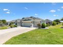 Side exterior of the home with mature landscaping and a spacious driveway at 1182 Allaire Loop, The Villages, FL 32163