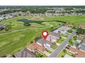 Aerial view of a home on a golf course with lush greenery and tranquil ponds at 11820 Se 178Th St, Summerfield, FL 34491