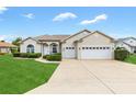 Inviting home with a three-car garage, lush lawn, and freshly manicured landscaping in daylight at 11884 Se 179Th St, Summerfield, FL 34491