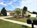 Charming single-story home with a well-manicured lawn, mature landscaping, and an attached two-car garage at 1231 Merion Dr, Mount Dora, FL 32757