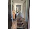 Inviting hallway with wood-look tile and decorative rug leading into the open-concept living space at 1231 Merion Dr, Mount Dora, FL 32757