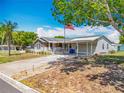 Exterior view of a well-kept single-story home with a spacious carport and flag pole at 1236 Elkhart Cir, Tavares, FL 32778