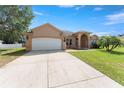 Stunning single-story home with a well-manicured lawn and a two-car garage, perfect for suburban living at 13336 Biscayne Dr, Grand Island, FL 32735