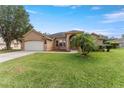 Single-story home with a well-manicured lawn and a two-car garage at 13336 Biscayne Dr, Grand Island, FL 32735