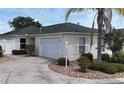 Well-maintained home featuring a two-car garage, mature landscaping, and a charming, quaint design at 1482 Azteca Loop, The Villages, FL 32162