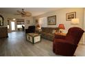 Cozy living room featuring stylish flooring, neutral paint, ceiling fan and comfortable furnishings at 1482 Azteca Loop, The Villages, FL 32162