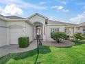 Charming single-story home with an arched entryway, lush landscaping, and well-kept lawn at 17471 Se 110Th Ter, Summerfield, FL 34491