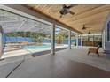 Covered outdoor pool and patio area with a waterfall feature, perfect for entertaining at 19627 Spring Oak Dr, Eustis, FL 32736