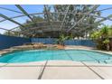 Beautiful backyard pool with a tranquil waterfall feature under a screened enclosure at 19627 Spring Oak Dr, Eustis, FL 32736