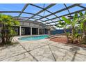 Backyard pool with a rock patio, lush landscaping, and covered patio area at 19627 Spring Oak Dr, Eustis, FL 32736