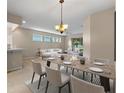 Elegant dining area with modern lighting fixture and neutral tones to highlight the room's open floor plan at 22217 Caledonia Dr, Leesburg, FL 34748