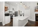 Bright kitchen featuring an island with quartz countertop, stainless steel appliances, and pendant lighting at 28924 Discovery Rd, Tavares, FL 32778
