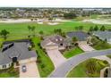 Aerial view of a house on a golf course with mature landscaping, and a patterned brick driveway at 2954 Cedar Grove Loop, The Villages, FL 32163