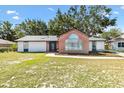 Beautiful home features a brick facade with arched window and a meticulously maintained lawn at 307 Water Shore Dr, Leesburg, FL 34748
