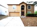 Front exterior of a two-story home featuring a two-car garage and arched entryway at 3329 White Blossom Ln, Clermont, FL 34711