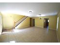 Open-concept living room with tile flooring, staircase, and natural light at 3329 White Blossom Ln, Clermont, FL 34711