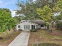 Inviting single-story home with a long driveway and mature landscaping at 34 Gordon Ct, Leesburg, FL 34788