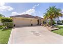 Attractive home with a well-kept lawn, pineapple driveway accent, and two-car garage at 3433 Nestlebranch Ave, The Villages, FL 32163