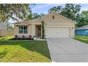 Attractive single-Gathering home featuring a lush lawn and an attached two-car garage at 35107 Sweet Leaf Ln, Leesburg, FL 34788