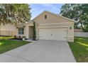 Beautifully designed house with a landscaped yard, a neutral color palette, and a two-car garage at 35107 Sweet Leaf Ln, Leesburg, FL 34788
