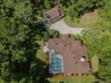 Aerial view of a house with a screened-in pool and a detached garage surrounded by lush greenery at 35350 County Road 439, Eustis, FL 32726