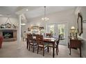 Formal dining room area featuring a fireplace, french doors, and elegant chandelier over the wood dining table at 35350 County Road 439, Eustis, FL 32726