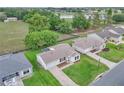 Aerial view of a well-maintained home, lush landscaping, and a community view with golf course and pond at 3590 Auburndale Ave, The Villages, FL 32162