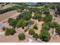 Aerial view of wooded property and neighborhood with houses and a lake in the distance at 43411 State Road 19, Altoona, FL 32702