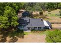 Aerial view of home with neutral exterior paint, mature landscaping and a screened-in porch at 43411 State Road 19, Altoona, FL 32702