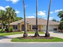 Charming single-story home with a well-maintained lawn, circular driveway, and prominent palm trees at 4547 Inverness Dr, Leesburg, FL 34748
